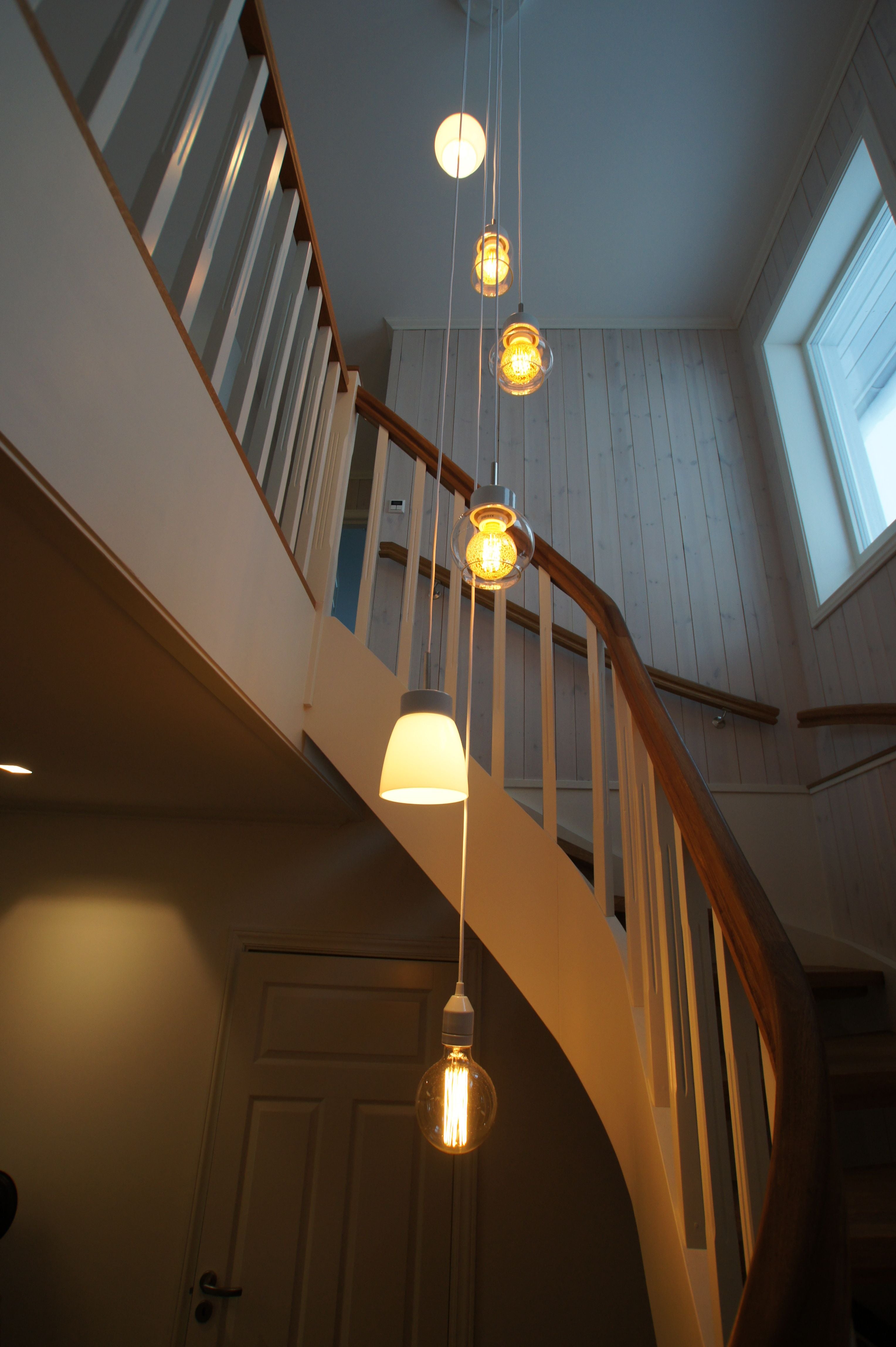 Verschiedene Smycka Pendelleuchten als Arrangement im Treppenhaus Porzellan E27 weiss klar | Ifö Electric